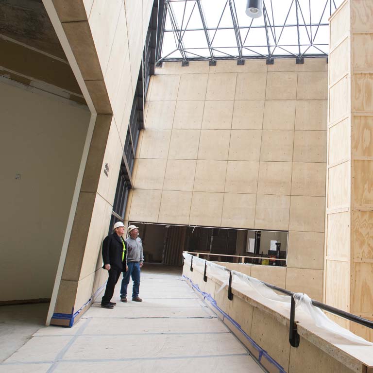 Two workers look at the ceiling of the Sidney and Lois Eskenazi Museum of Art.